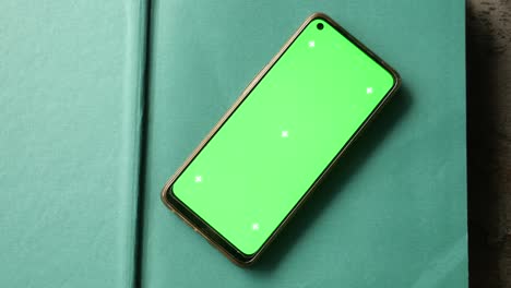 smartphone with green screen on a book