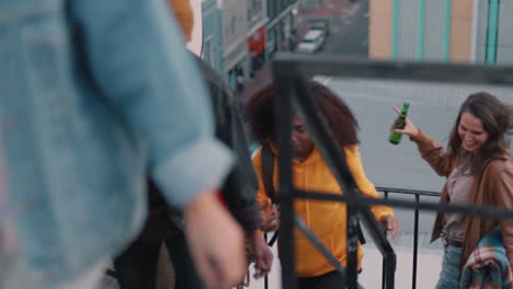 group-of-young-multiracial-friends-walking-up-fire-escape-stairs-ready-for-rooftop-party-chatting-sharing-excitement-for-weekend-celebration