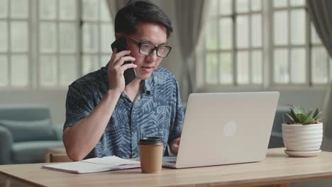 Male Talking On Phone During Work With Laptop Computer At Home, Video In 4K