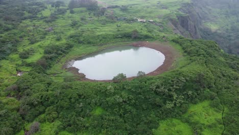 Aerial-view-of-sacred-lake-at-the-Brahmagiri-hill-in-the-Western-Ghats-of-Maharashtra-during-monsoon,-Nashik,-India