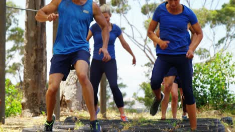 Personas-En-Forma-Practicando-Entrenamiento-De-Carrera-De-Obstáculos-Con-Neumáticos-4k