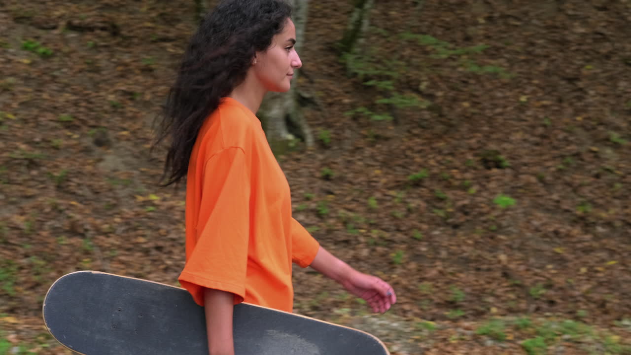 가을의 숲에서 스케이트보드를 가진 십대