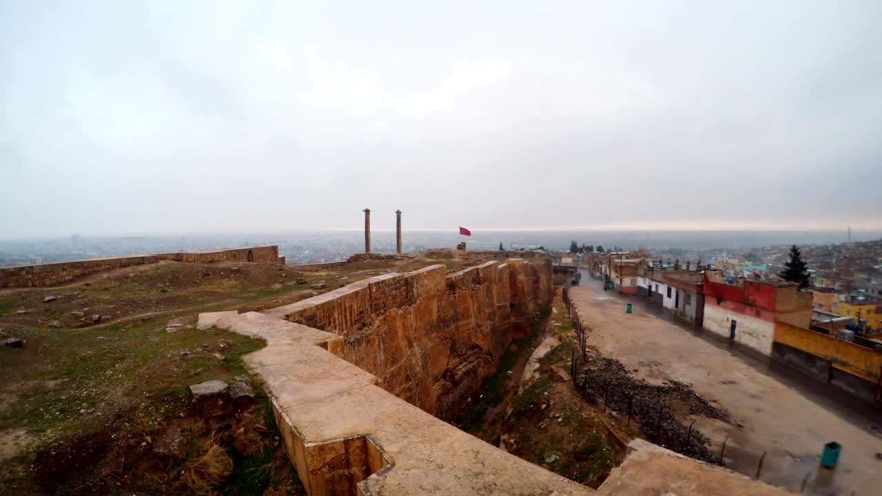 la zanja hecha a mano del castillo de urfa divide las ruinas y los barrios marginales lejos dos columnas nieve y lluvia