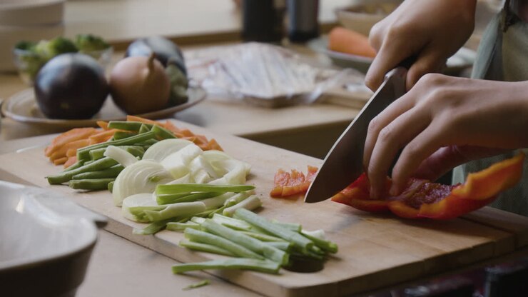 Woman Chopping Vegetables in Kitchen