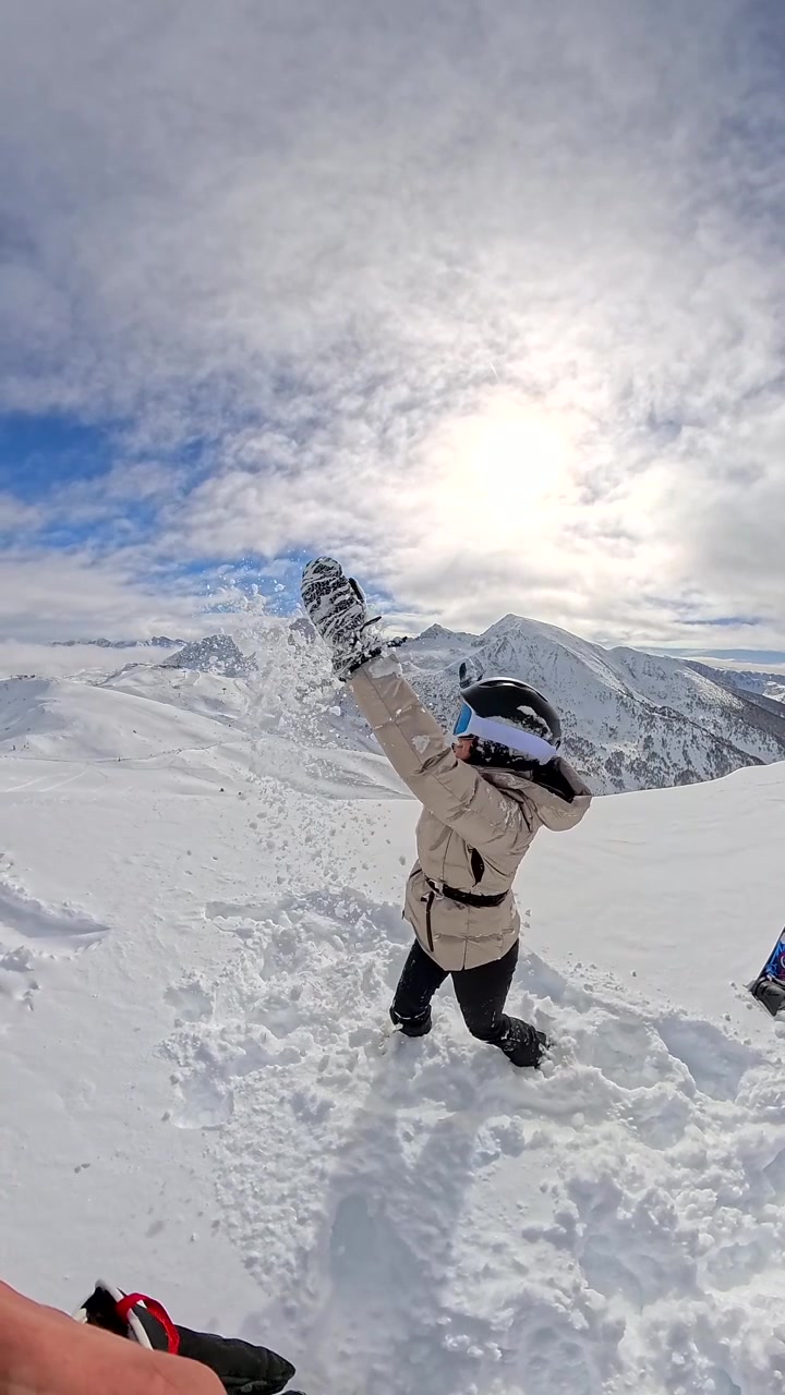 Happy Woman Playing in Deep Snow on Mountain Peak