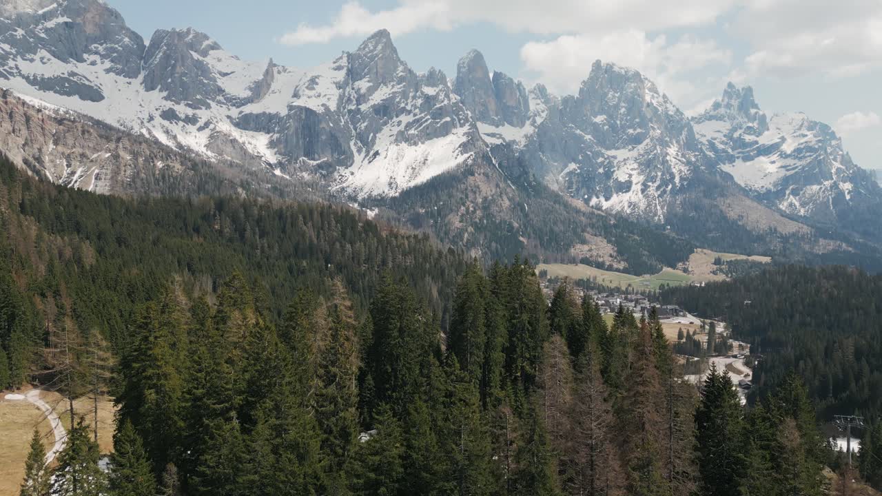 montañas escarpadas nevadas de las dolomitas con bosque de coníferas en primer plano