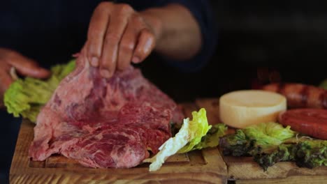 preparing raw beef with fresh vegetables on wooden platter for a rustic meal
