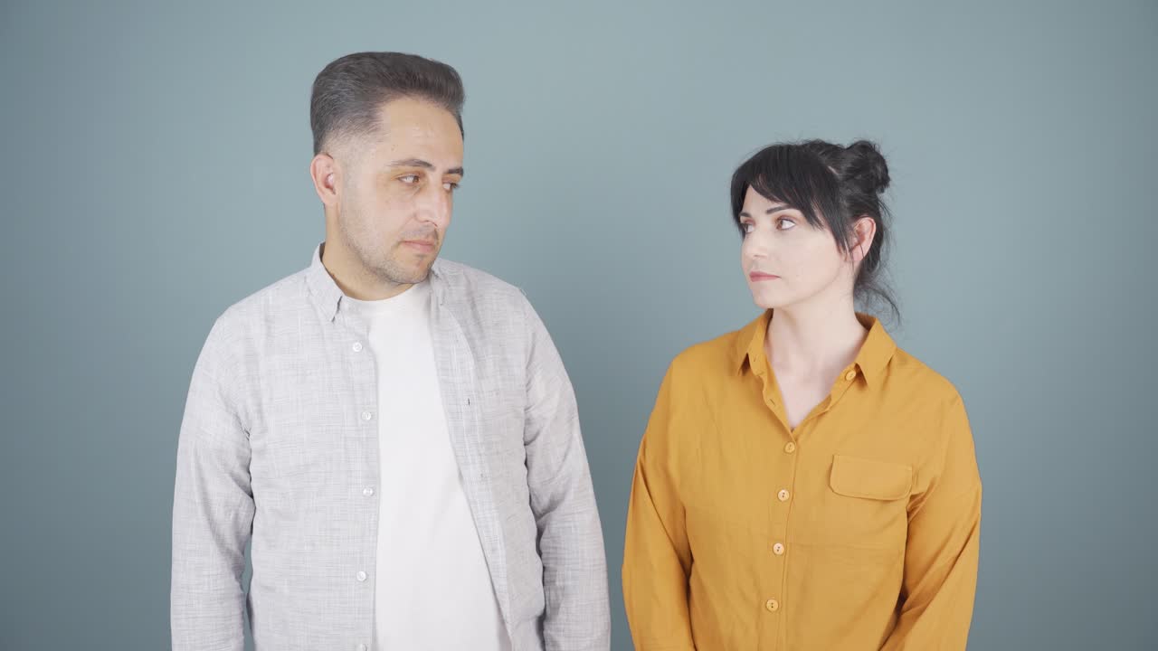 남자와 여자는 둔한 표정으로 서로를 쳐다보고 있습니다.