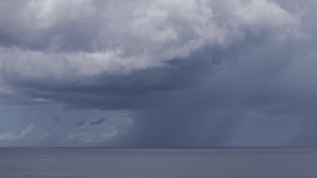 Large storm clouds building over a calm ocean at Mabua Beach, Surigao City, Surigao del Norte, Mindanao, Philippines.