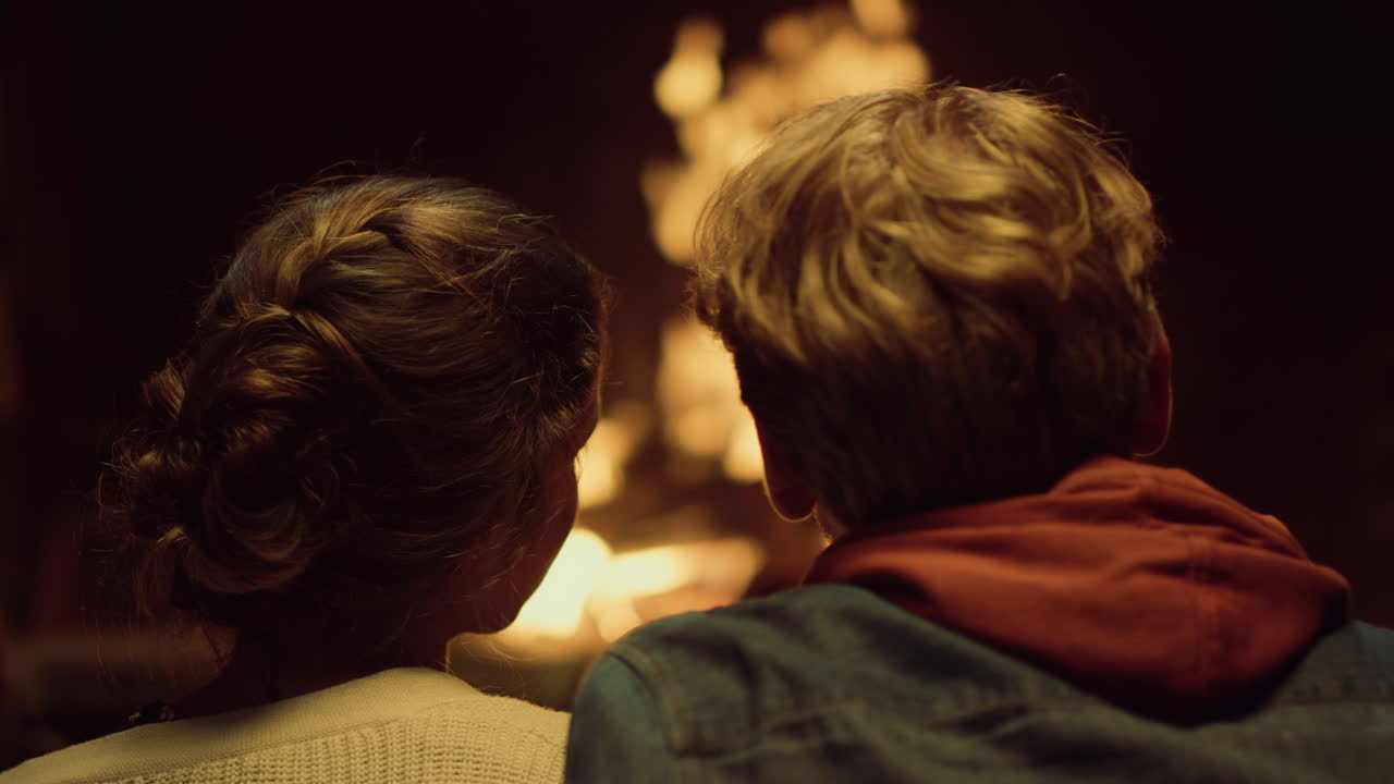 пара наслаждается огнем во время свидания. двое влюбленных обнимаются у домашнего камина