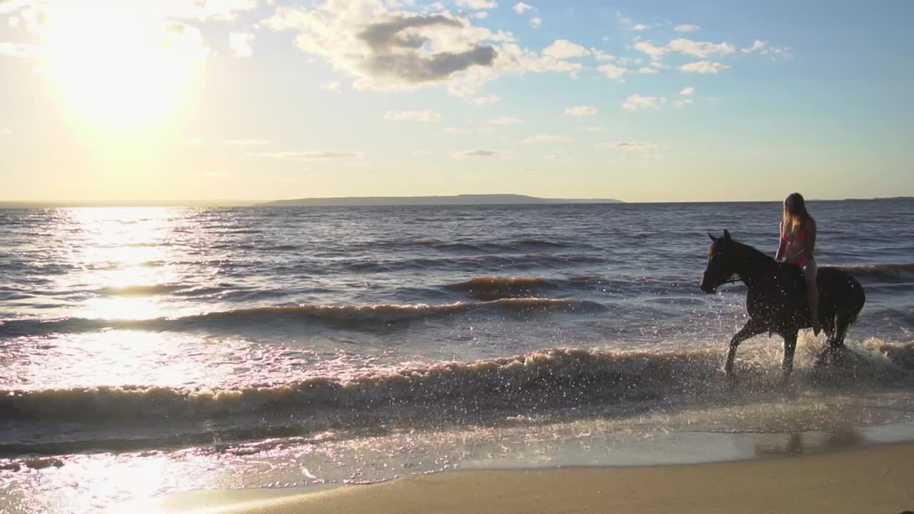 mulher a cavalo numa praia ao pôr do sol
