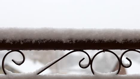 valla de metal forjado con formas decorativas cubiertas de nieve durante las nevadas