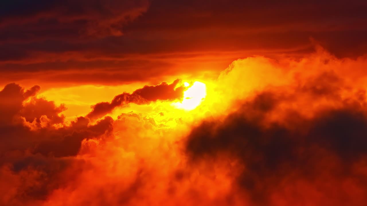 Fiery sunset with glowing clouds and sunbeams bursting through vivid orange sky, backdrop