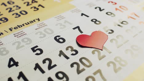 red paper heart appears on the calendar on the 14th of february. valentine's day - the holiday of love