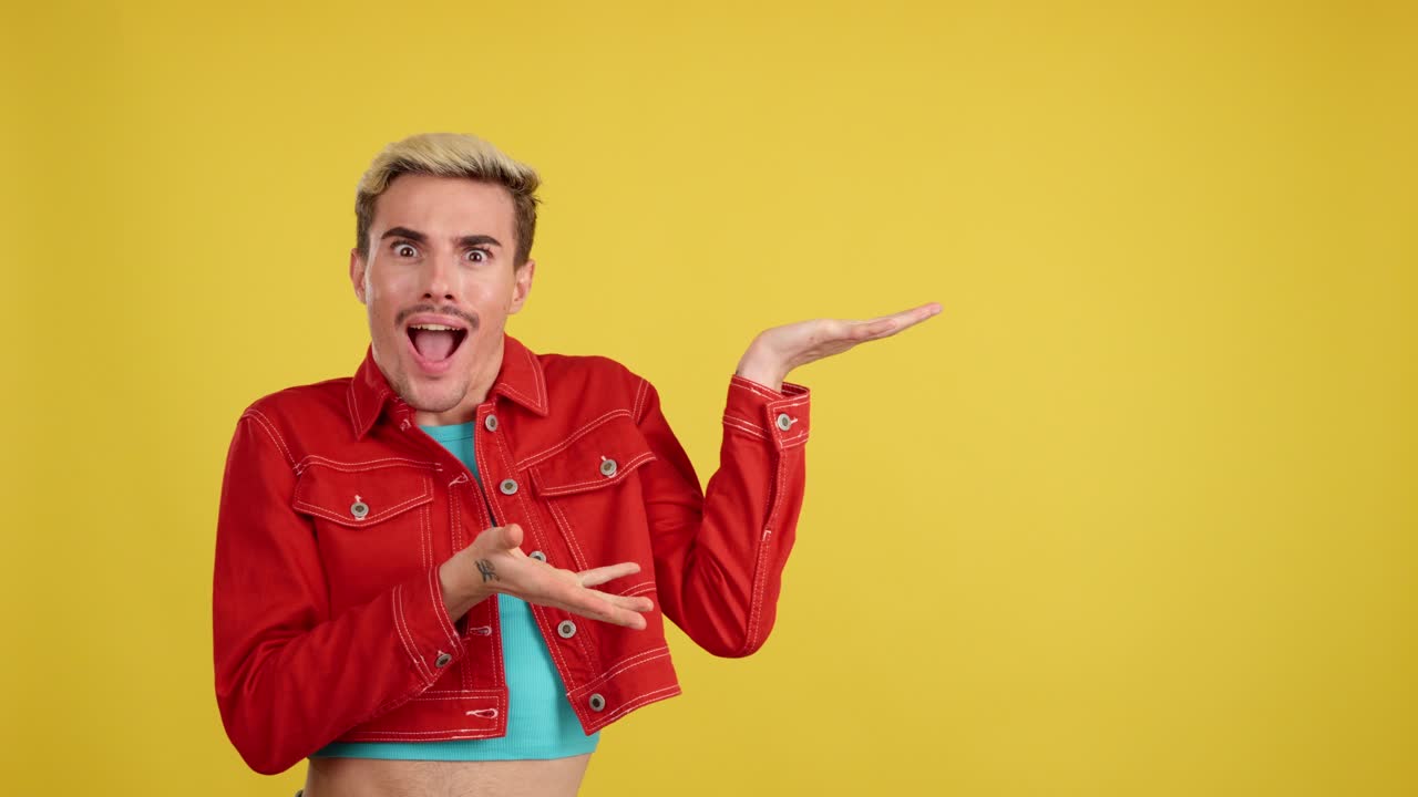 Man in red jacket pointing on yellow background