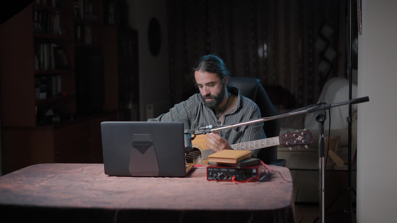 hombre tocando la guitarra acústica en el estudio casero