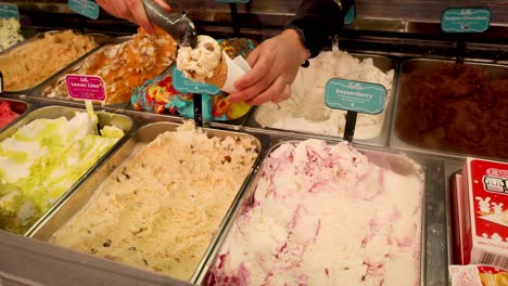 person scooping ice cream into a cone