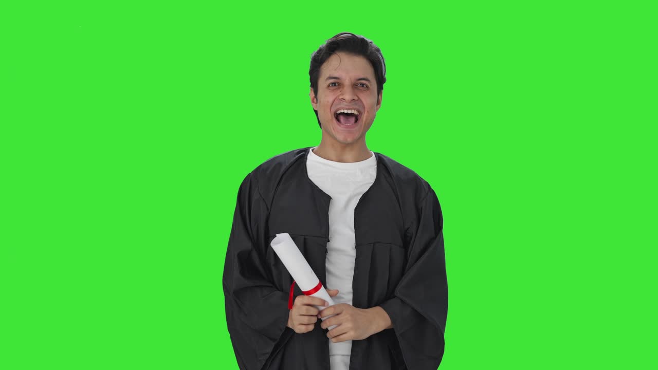 Studente universitario indiano che lancia il tocco alla laurea su schermo verde