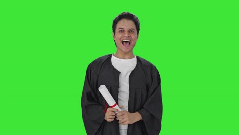 estudiante universitario indio arrojando gorra en la pantalla verde de la graduación