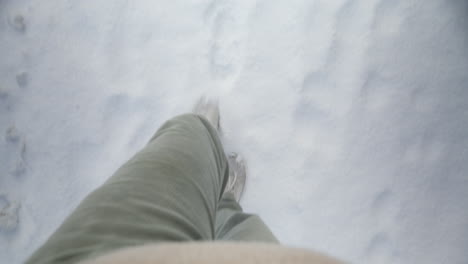 pov walking through a snow-covered path with footprints