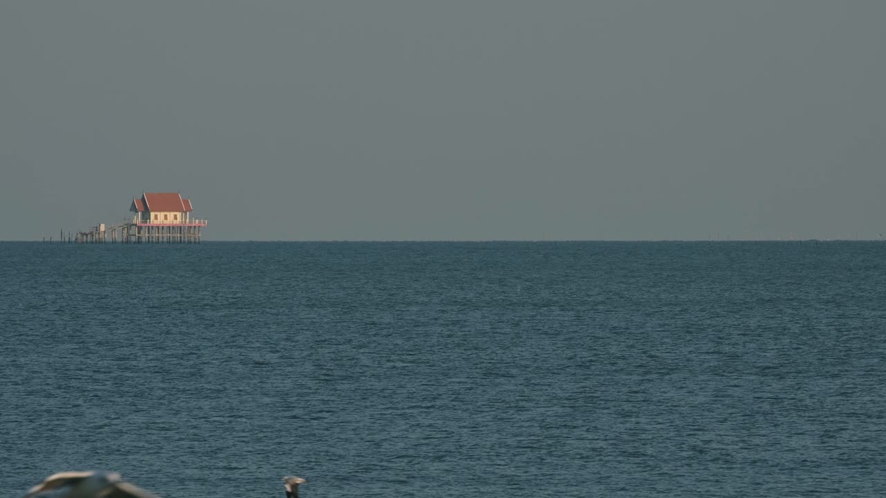 멀리서 바다 한가운데에 있는 불교 사원, 바다 새들이 날아다니는 모습, 태국