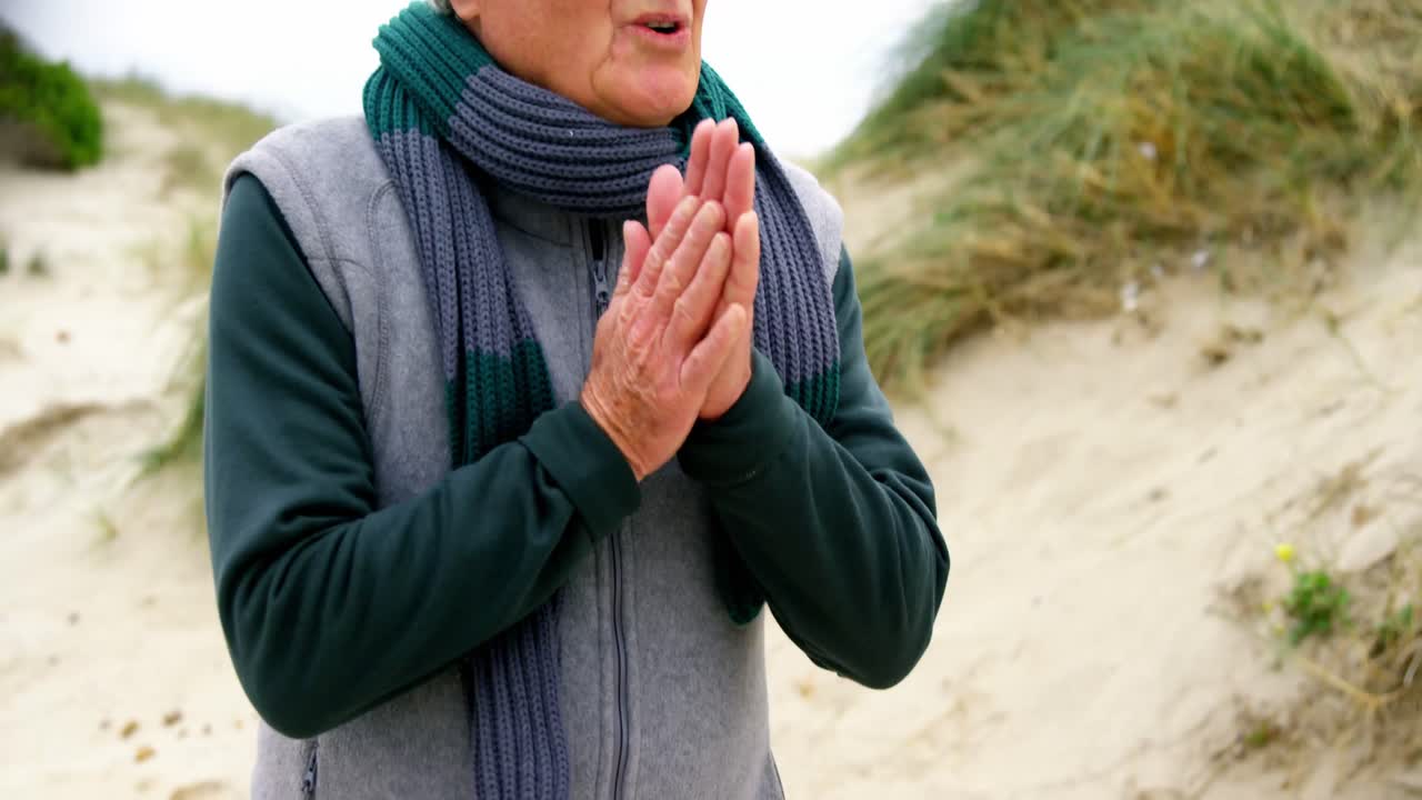 스웨터를 입은 수석 남자가 추위를 느끼고 있습니다.