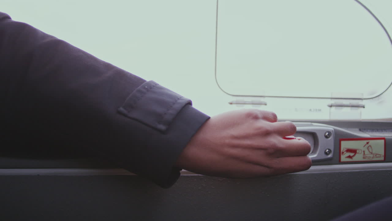 mujer mano abierta cerradura de la puerta en el avión. desbloquear la puerta dentro de la cabina del avión