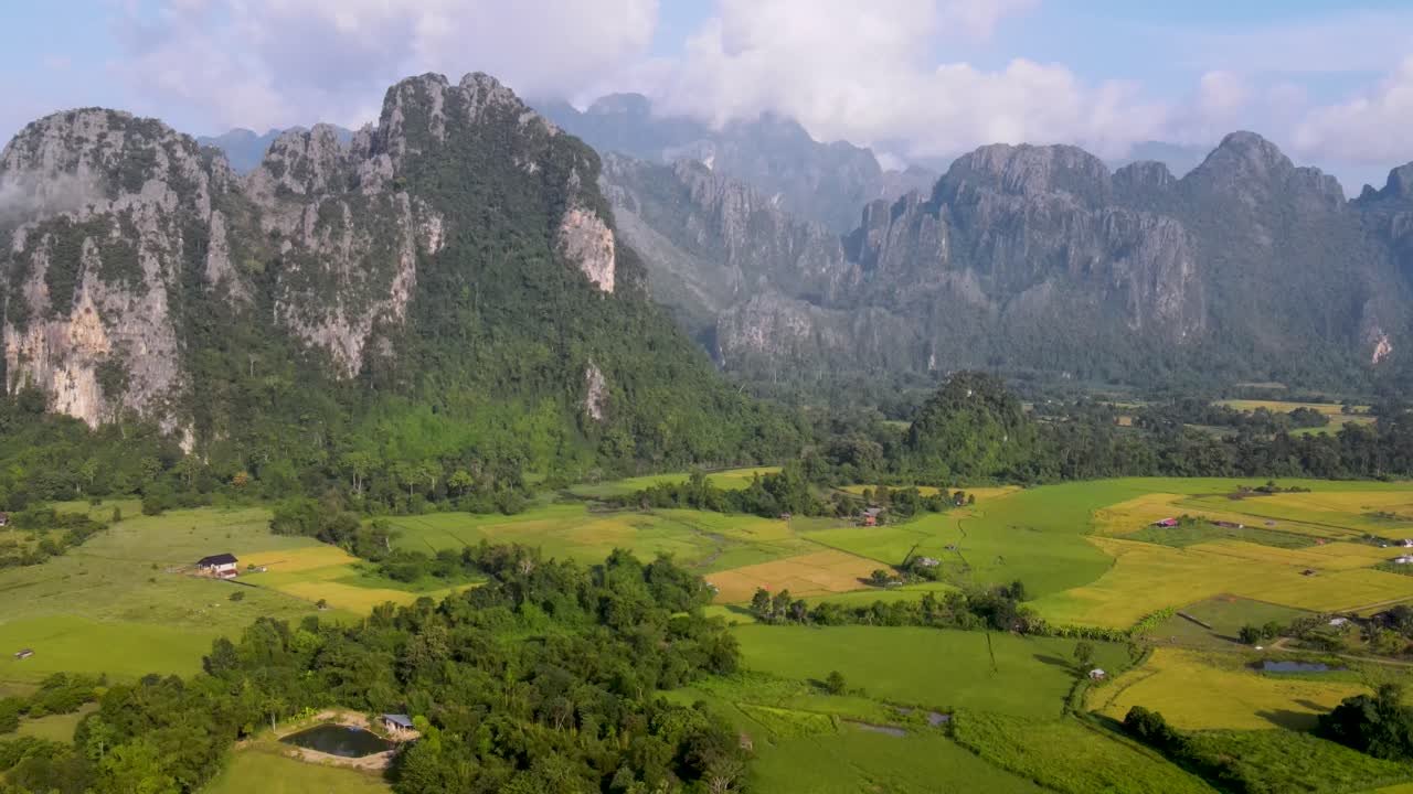 Aerial View Of Green Farming Fields With Soaring Forested Mountain Landscape At Vang Vieng