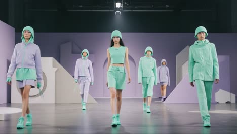 a captivating fashion showcase featuring models in stylish mint green outfits on a modern runway with minimalist set design