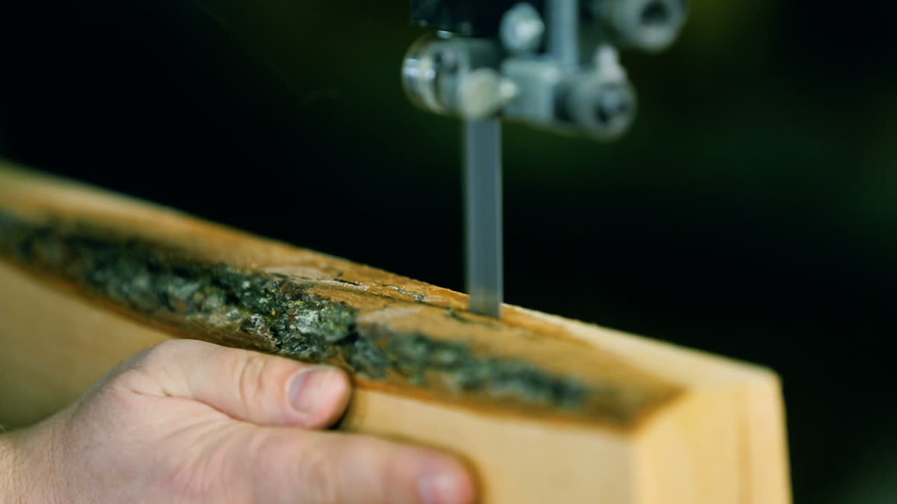 Man Uses An Electric Saw To Cut Wooden Planks. Carpenter is sawing a wooden plank with jig saw machine in carpentry workshop