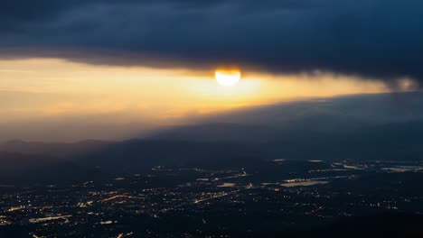 dramatic sunset over a twinkling cityscape and mountains