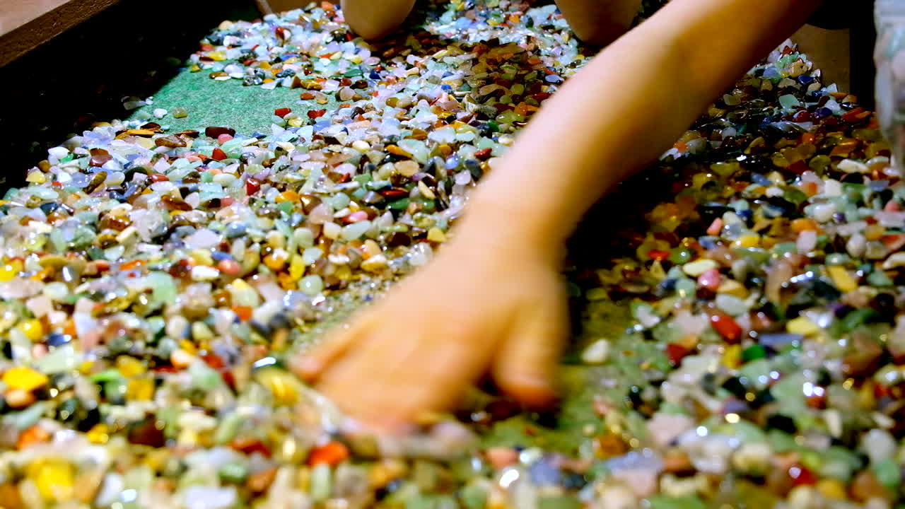 아이들은 손으로 다채로운 보석들을 골라 니다.