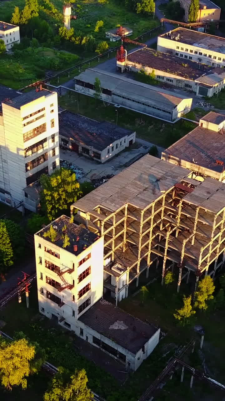 Old Ruinous Factory At Sunset. Discard old industrial factory exterior with buildings and smokestack Vertical video