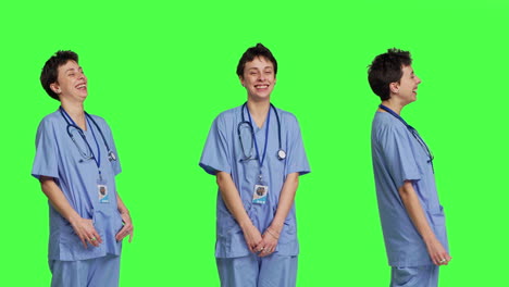 un asistente médico sonriente y alegre de pie contra un telón de fondo verde