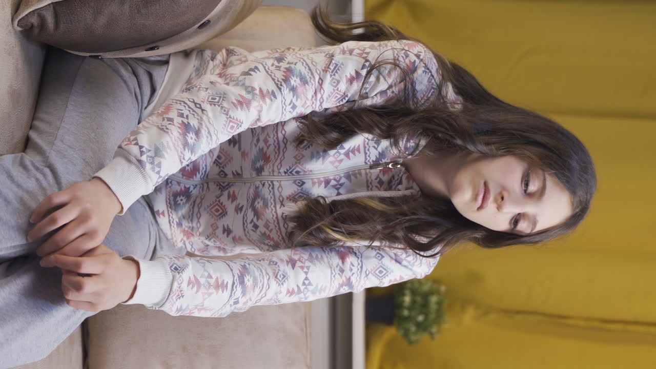 video vertical de una mujer joven pensando en un tema por la noche en casa.