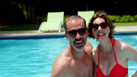 couple taking a selfie on mobile phone in swimming pool