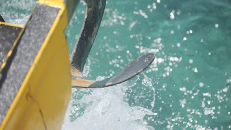 View-of-the-anchor-hanging-off-a-boat-cruising-through-beautiful-blue-waters