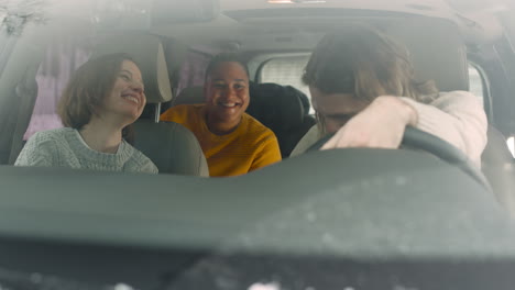 tres amigos felices hablando y pasando un buen rato juntos mientras están sentados en el auto en un día de invierno 1