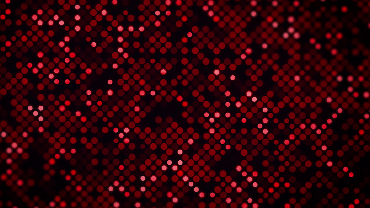Dark background featuring a dense grid of red circles with varying brightness and a subtle blur effect. Red and black circular dot pattern abstract loop animation