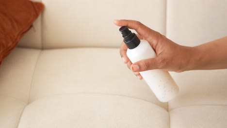 cleaning a sofa with a spray bottle