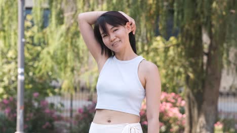 confident woman wearing crop tank top in city park during daytime
