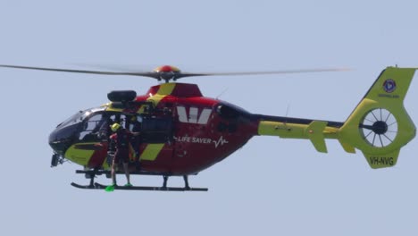 helicopter with crew performing aerial rescue operation