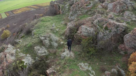 vista aérea de un hombre caminando en una cima de una montaña rocosa en la antigua ciudad de kabile en bulgaria