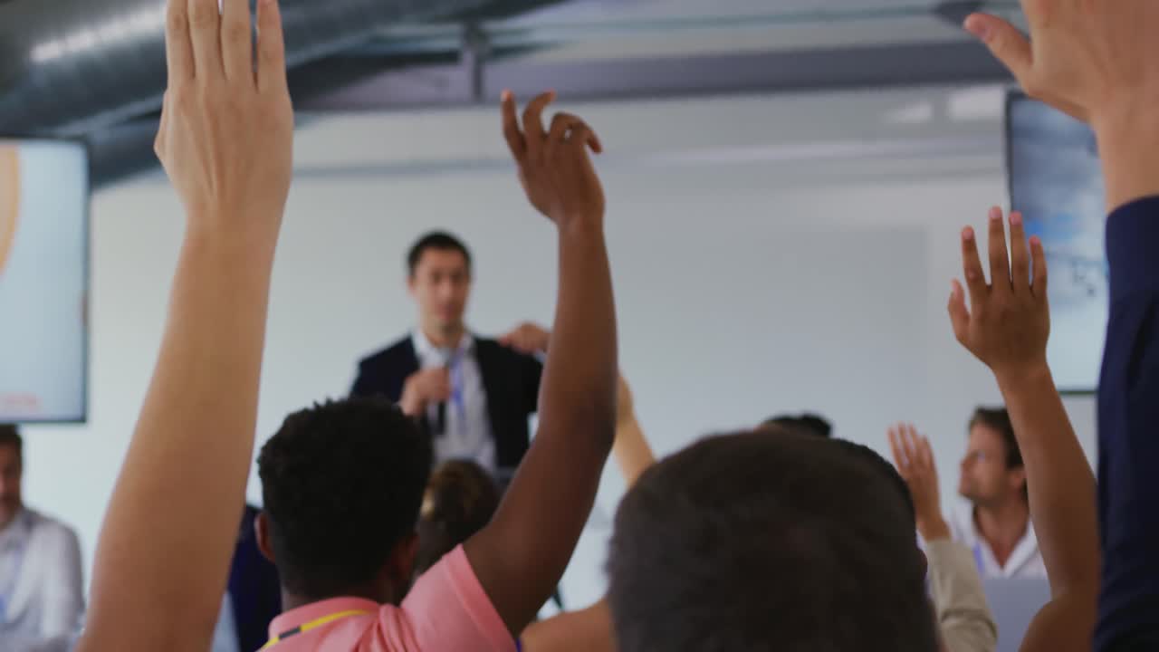 Uomo d'affari che invita il pubblico a porre domande a una conferenza aziendale