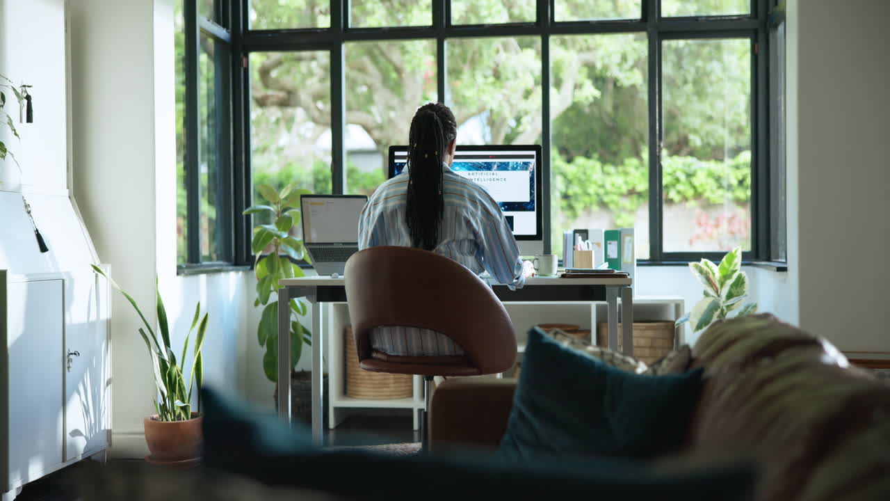 Woman Working on Computer in Home Office with Garden View