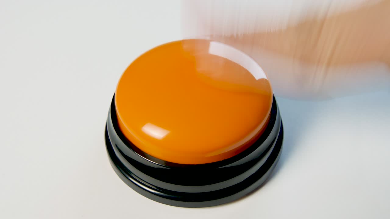 joven presionando el botón naranja con un dedo y la palma de la mano. presiona un botón redondo brillante, vista superior. activación, lanzamiento de algo. encender y apagar.