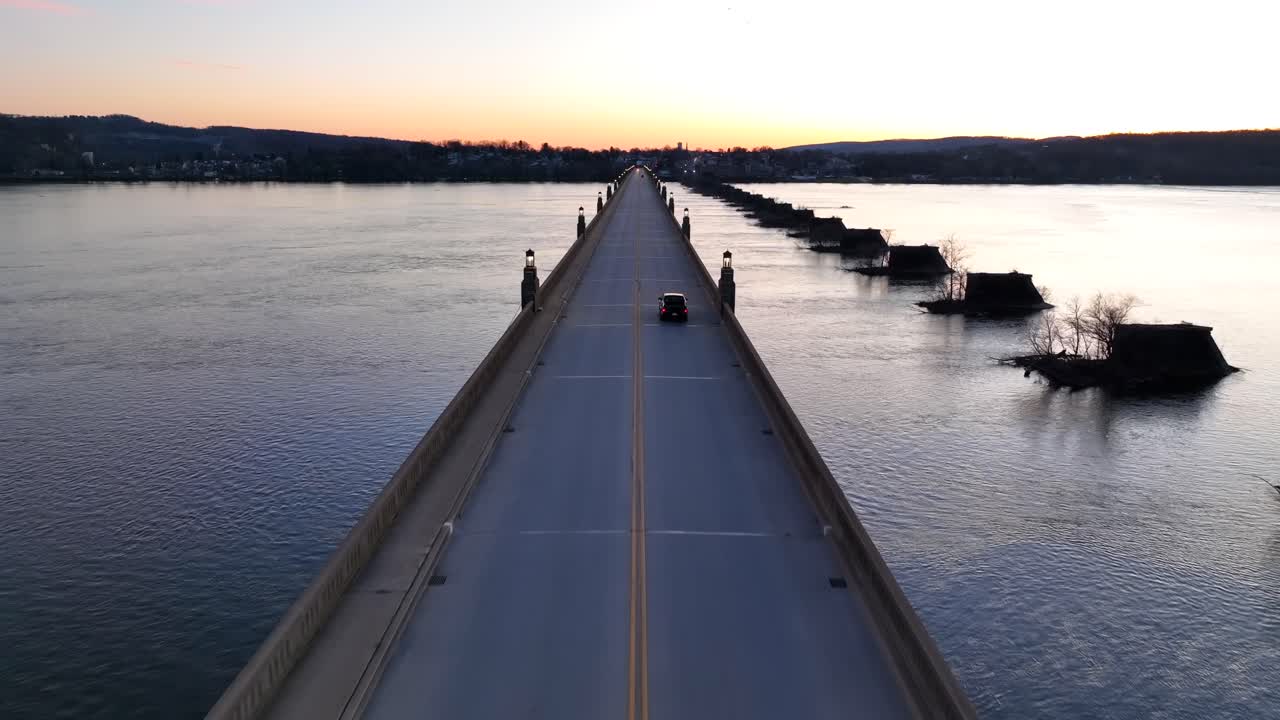 Aerial flyover Columbia&ndash;Wrightsville Bridge following driving cars after sunset Behind hills at horizon