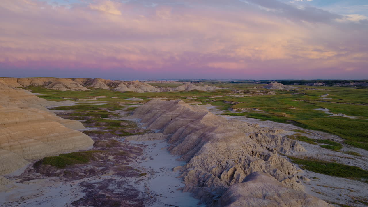 Drone Flight Over Rugged Badlands Formations in Fiery Evening Skies