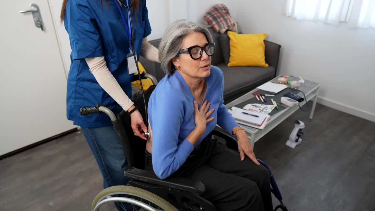 Operatore sanitario che visita un'anziana in sedia a rotelle a casa
