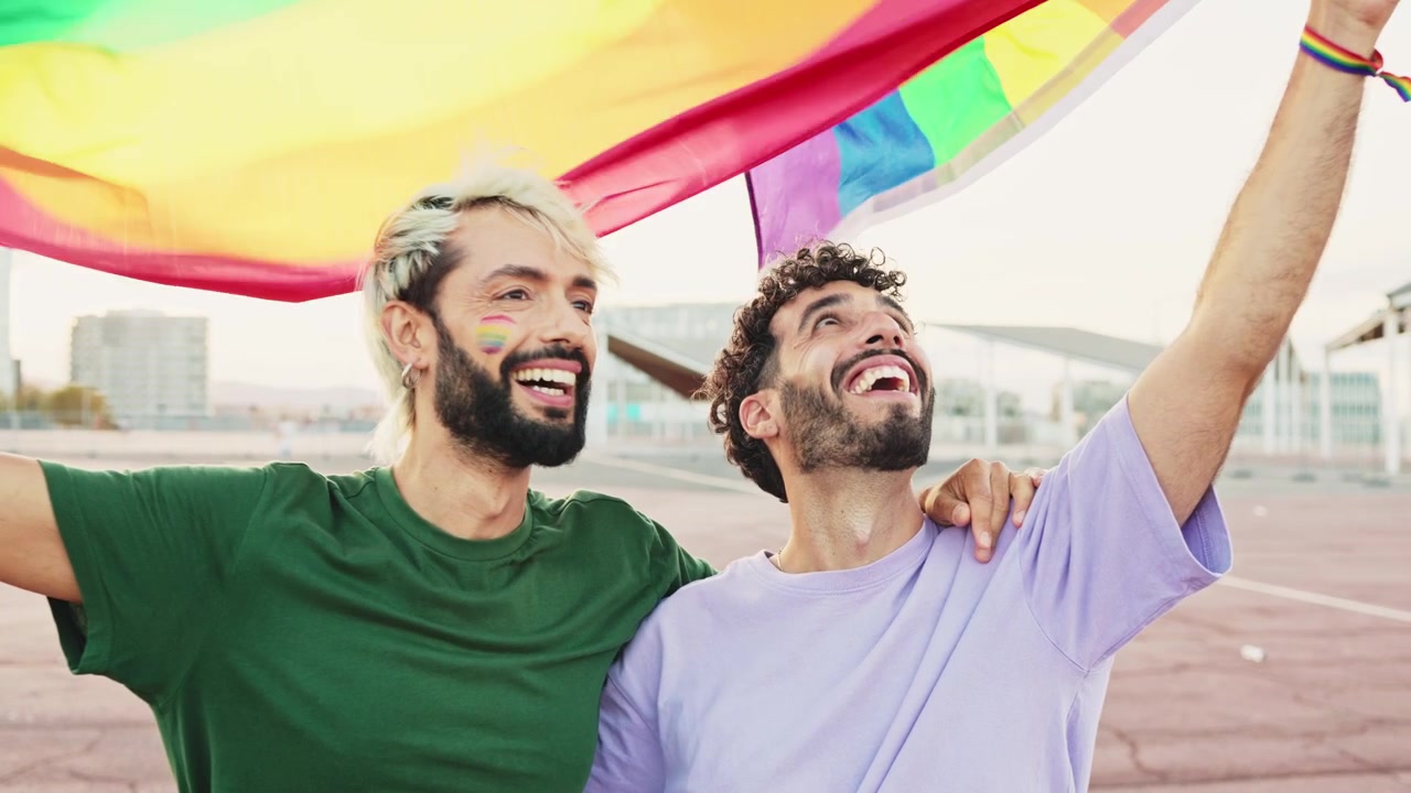 Happy Gay Couple Holding Rainbow Flag Together